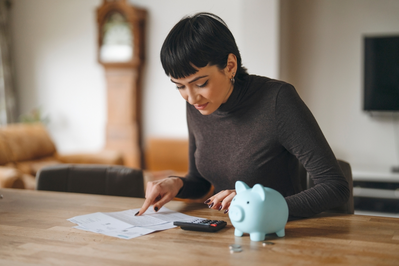 woman with paperwork and piggy bank