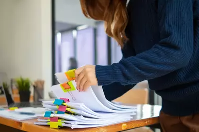 woman looking through pile of forms