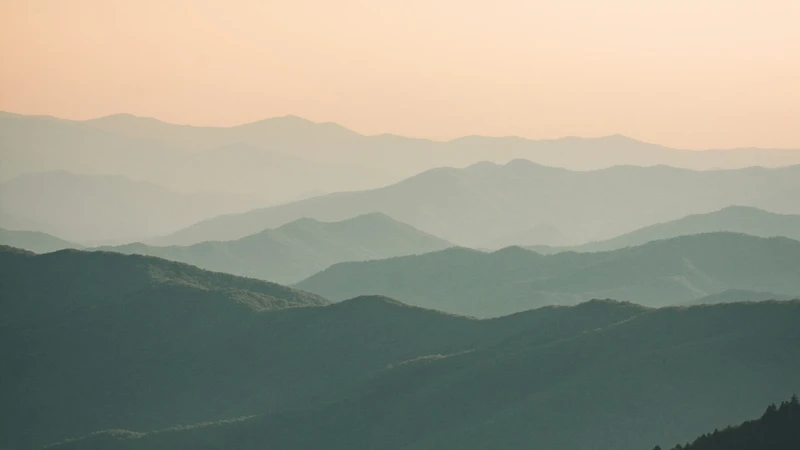 Layered East Tennessee mountain ridges in blue-green haze at dusk, with no people, buildings, logos, or readable text.