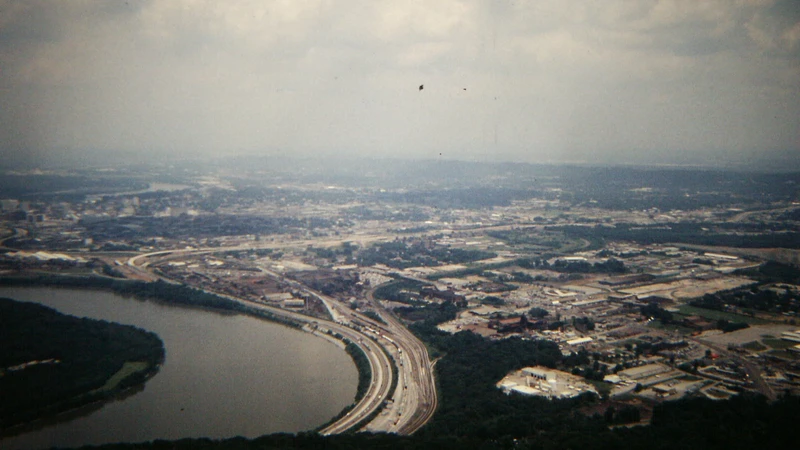 Aerial view of a wide Tennessee river bend lined with wooded hills and homes along the bank, no people, logos, or text