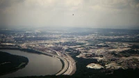 Aerial view of a wide Tennessee river bend lined with wooded hills and homes along the bank, no people, logos, or text