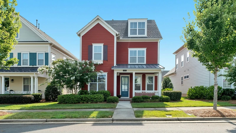 Red brick two-story Tennessee home with white trim, a green lawn, and a front walkway on a clear day, no people, logos, or text