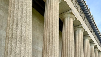 Row of tall white stone columns on a government building under soft daylight, no people, logos, or text