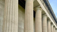 Row of tall white stone columns on a government building under soft daylight, no people, logos, or text