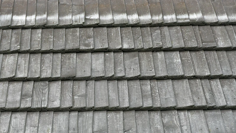 Close view of weathered gray wooden roof shingles in overlapping rows