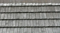 Close view of weathered gray wooden roof shingles in overlapping rows